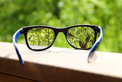 eyeglasses in the hand over blurred tree background